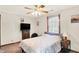 Neutral bedroom with a ceiling fan, television on dresser, and large window with a view at 4590 Turkey Track Rd, Martinsville, IN 46151