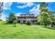 Spacious home on a lush green hill, boasting a large wrap-around porch with stairs at 4590 Turkey Track Rd, Martinsville, IN 46151
