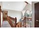 Upstairs hallway features a chandelier, wood railing, and an open view to the foyer at 4590 Turkey Track Rd, Martinsville, IN 46151