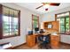 Bright home office with wooden desk and multiple windows offering natural light at 4590 Turkey Track Rd, Martinsville, IN 46151