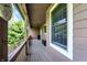 Inviting covered porch with wood flooring and railings offering views of the surrounding greenery at 4590 Turkey Track Rd, Martinsville, IN 46151