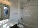 Modern bathroom featuring a tub-shower combo, tiled wall, vanity, and a well-lit mirror at 477 Mariposa Trl, Carmel, IN 46032