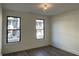 Sunlit bedroom with two windows, modern light fixture, and wood-look flooring offers a stylish space at 477 Mariposa Trl, Carmel, IN 46032
