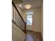 Inviting entryway with natural light, modern light fixture, and wooden staircase with black metal railings at 477 Mariposa Trl, Carmel, IN 46032
