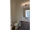 Tastefully decorated powder room featuring modern vanity with granite counter and updated fixtures at 477 Mariposa Trl, Carmel, IN 46032