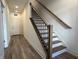 Modern staircase with wood and white risers, complemented by a wood and black railing at 477 Mariposa Trl, Carmel, IN 46032