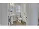 Clean bathroom with a pedestal sink, toilet, and a window with blinds at 649 Washington St, Fortville, IN 46040
