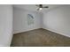 Bright, carpeted bedroom with a window, ceiling fan and neutral decor at 649 Washington St, Fortville, IN 46040