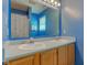 Bathroom featuring a double sink vanity with a large mirror and warm wood cabinetry at 6843 Long Run Dr, Indianapolis, IN 46268