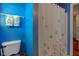 Bathroom featuring white toilet and butterfly-themed shower curtain with bright blue walls at 6843 Long Run Dr, Indianapolis, IN 46268