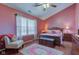 Comfortable bedroom with pink walls, ceiling fan, window and light-colored carpet at 6843 Long Run Dr, Indianapolis, IN 46268