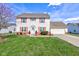 Charming two-story home with well-manicured lawn, red shutters and an attached garage at 6843 Long Run Dr, Indianapolis, IN 46268