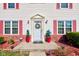 Close up of the front door with a decorative wreath and red potted plants at 6843 Long Run Dr, Indianapolis, IN 46268
