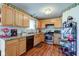 Well-lit kitchen with wooden cabinets, granite countertops, modern appliances, and decorative strawberry wallpaper at 6843 Long Run Dr, Indianapolis, IN 46268