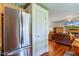 Close-up of stainless steel refrigerator, with view of the dining area and living room with TV above the fireplace at 6843 Long Run Dr, Indianapolis, IN 46268