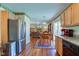 Bright kitchen with stainless steel appliances and wood cabinets, opening to a cozy dining area and living room at 6843 Long Run Dr, Indianapolis, IN 46268