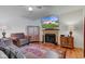 Comfortable living space with a fireplace, soft armchairs, and a TV displaying an exterior shot of the house at 6843 Long Run Dr, Indianapolis, IN 46268