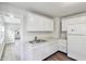 Bright kitchen featuring white cabinets, stainless steel sink, and wood-look flooring at 741 N Linwood Ave, Indianapolis, IN 46201