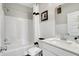 Bright bathroom featuring a tub-shower combo, white subway tiles, and a white vanity with a square sink at 7512 Manor Lake Ln, Indianapolis, IN 46268