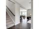 Open-concept entryway with dark hardwood flooring and carpeted stairs leading to the upper level at 7523 Fallsworth Dr, Avon, IN 46123