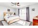 Bright bedroom with a wood-frame bed, a ceiling fan, and sheer purple curtains at 7816 E St Joseph St, Indianapolis, IN 46219