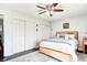 Cozy bedroom with a light wood bed frame, ceiling fan, and closet doors at 7816 E St Joseph St, Indianapolis, IN 46219