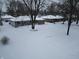 Charming single-story homes with snow-covered yards and mature trees create a peaceful winter scene at 7816 E St Joseph St, Indianapolis, IN 46219