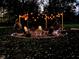 Relaxing outdoor seating arrangement around a fire pit, highlighted by festive string lights and lush green surroundings at 7816 E St Joseph St, Indianapolis, IN 46219