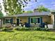 A charming stone home boasts blue shutters and a lovely front porch at 7816 E St Joseph St, Indianapolis, IN 46219