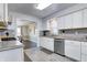 Well-lit kitchen featuring white cabinets, stainless steel appliances and tile backsplash at 7816 E St Joseph St, Indianapolis, IN 46219