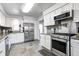 Spacious kitchen with stainless steel appliances, white cabinets, and tile flooring and backsplash at 7816 E St Joseph St, Indianapolis, IN 46219
