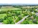 Expansive aerial view of a lush, green property with mature trees and winding paths at 905 S Maple St, Fortville, IN 46040