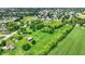 Aerial shot of a property that features an expansive, green field, mature trees, and a pond at 905 S Maple St, Fortville, IN 46040