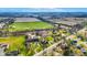 An aerial view of a home with a lush pond, road, and greenery at 905 S Maple St, Fortville, IN 46040