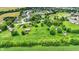 An aerial showcasing a property with green field, pond, and mature trees at 905 S Maple St, Fortville, IN 46040