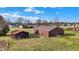 Aerial image highlighting the various sheds and outbuildings, set against a blue sky and green landscape at 905 S Maple St, Fortville, IN 46040