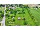 Aerial of property with green field, barn, and pond at 905 S Maple St, Fortville, IN 46040