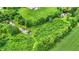 Aerial of a property with expansive green fields, a pond, and mature trees at 905 S Maple St, Fortville, IN 46040