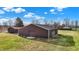 Several outbuildings sit on a large lot in a quiet rural neighborhood on a sunny day at 905 S Maple St, Fortville, IN 46040