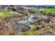 Aerial shot of a tranquil pond surrounded by bare trees in a rural neighborhood at 905 S Maple St, Fortville, IN 46040