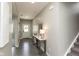 Inviting entryway with gray walls, wood floors, stylish console table, and a view of the front door with a wreath at 9709 Tampico Chase, Fishers, IN 46040