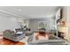 Spacious living room with hardwood floors, a plush grey sectional, and a brick fireplace at 10145 Northwind Dr, Indianapolis, IN 46256