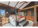 Main bedroom with ceiling fan and lights, exposed wood beams, and a large four-poster bed at 10313 W 225 S, Columbus, IN 47201