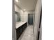 Bathroom featuring double sinks, marble tiling, black cabinetry, and a separate toilet and shower at 10950 N Heirloom Dr, Monrovia, IN 46157