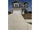 Two story home boasts vinyl siding, stone accents, two car garage, and a concrete driveway at 10950 N Heirloom Dr, Monrovia, IN 46157