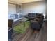 Living room featuring a large gray sofa, a clear topped coffee table, and dark wood floors at 10950 N Heirloom Dr, Monrovia, IN 46157