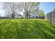 Sprawling backyard featuring a well-maintained lawn, mature trees, and a distant view of the home with a pergola at 11458 Falling Water Way, Fishers, IN 46037