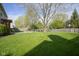 Expansive backyard featuring a lush lawn, mature trees, and a cozy firepit area, perfect for outdoor entertaining at 11458 Falling Water Way, Fishers, IN 46037
