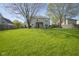 Large, green backyard featuring mature trees, a manicured lawn, and a charming view of the home with a pergola at 11458 Falling Water Way, Fishers, IN 46037