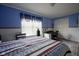 Sunlit bedroom featuring a comfortable bed, workspace, and bright blue walls at 11458 Falling Water Way, Fishers, IN 46037